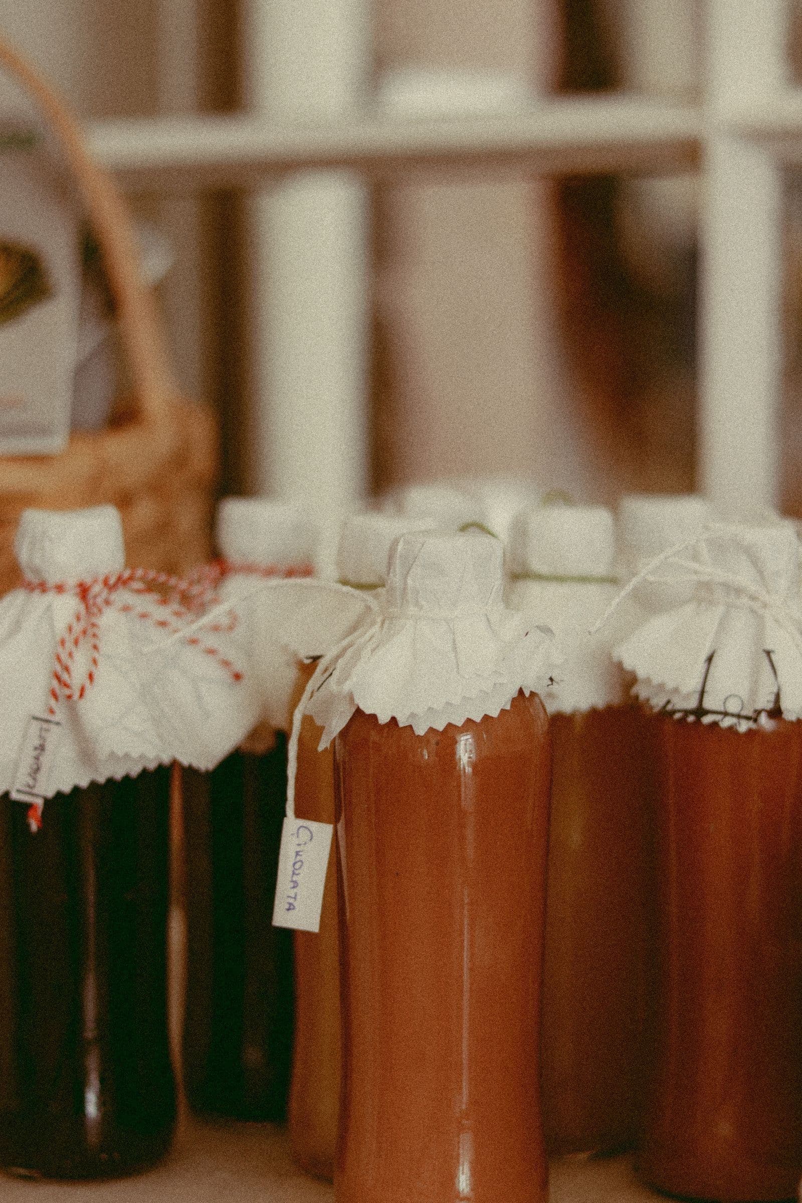 A row of hand-bottled drinks with cloth covers and string