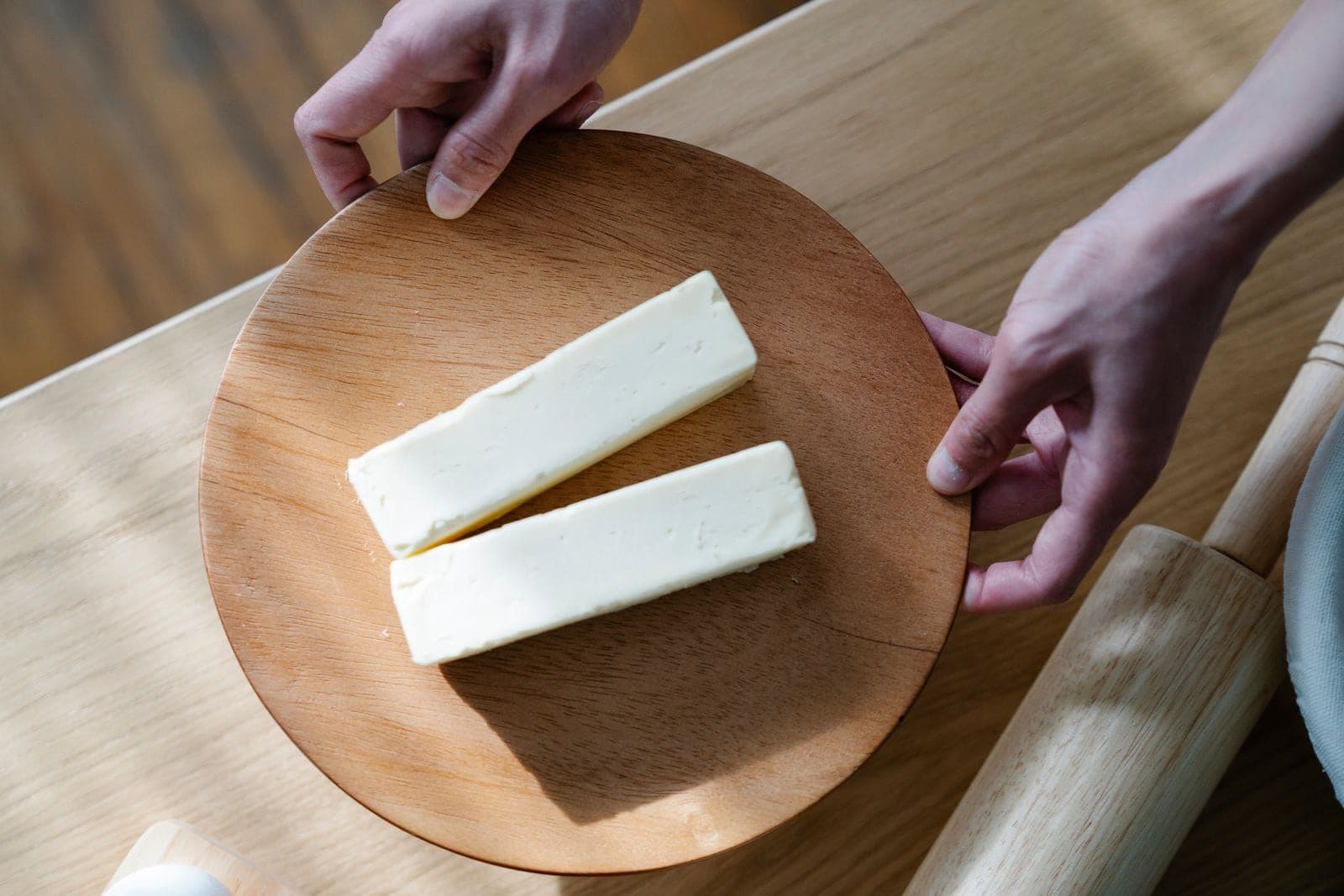 Two blocks of hand-churned butter on a wooden serving board