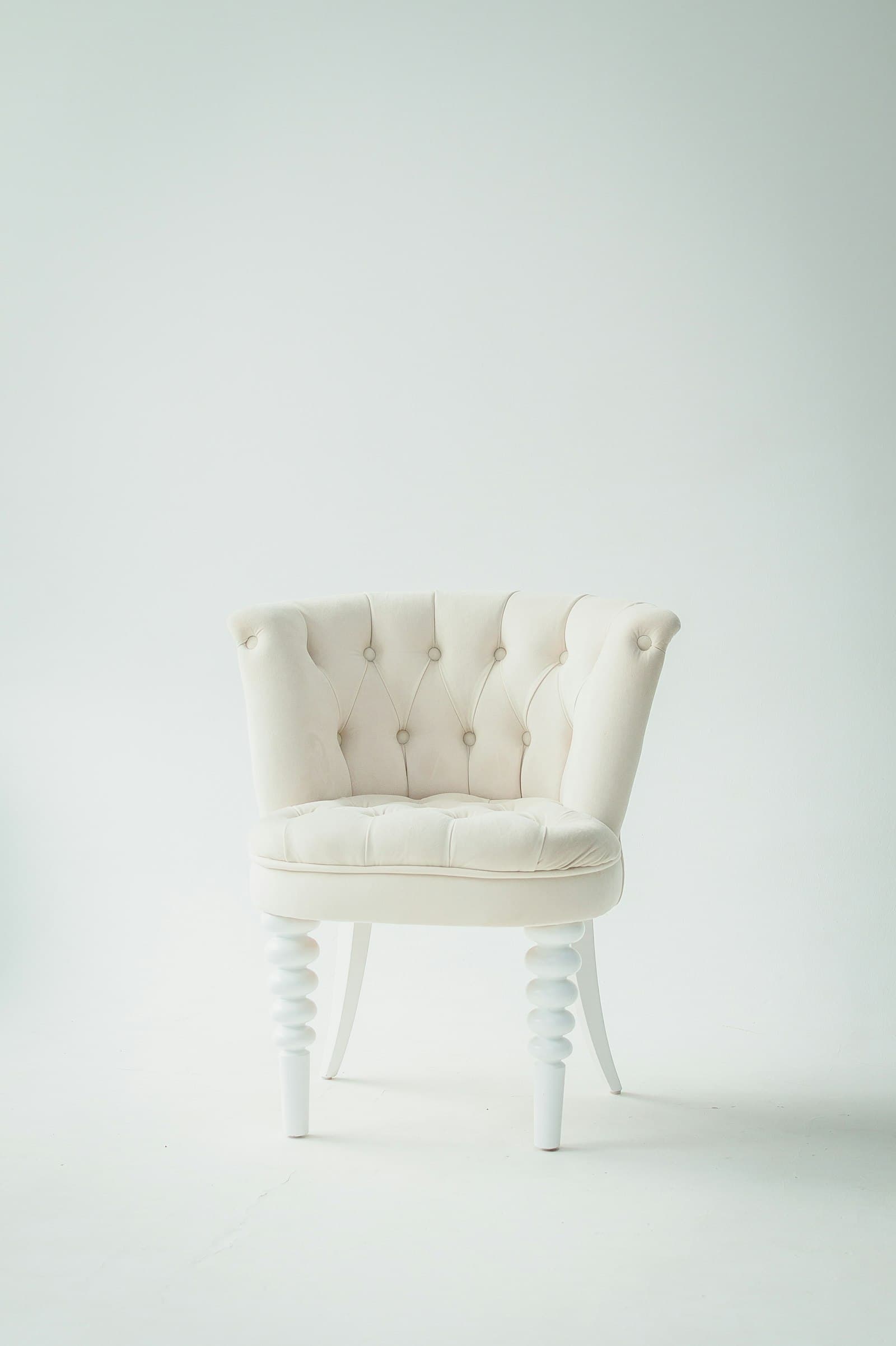 An upholstered chair with turned wooden legs
