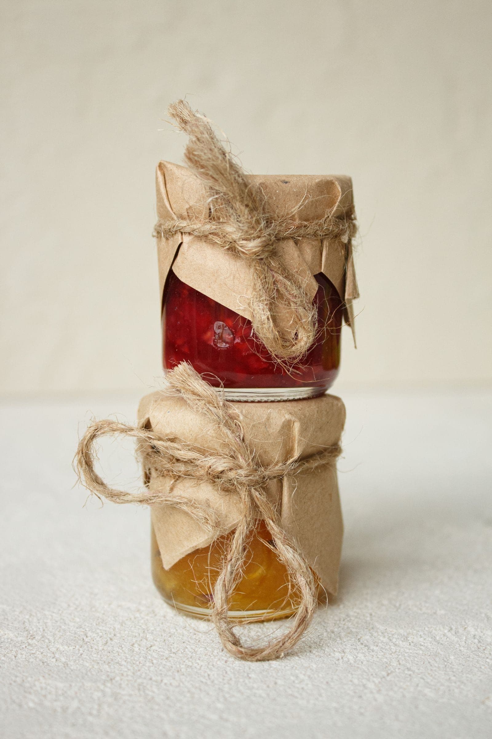 Paper-wrapped preserve jars tied with twine, stacked in the Swanbach farmhouse kitchen