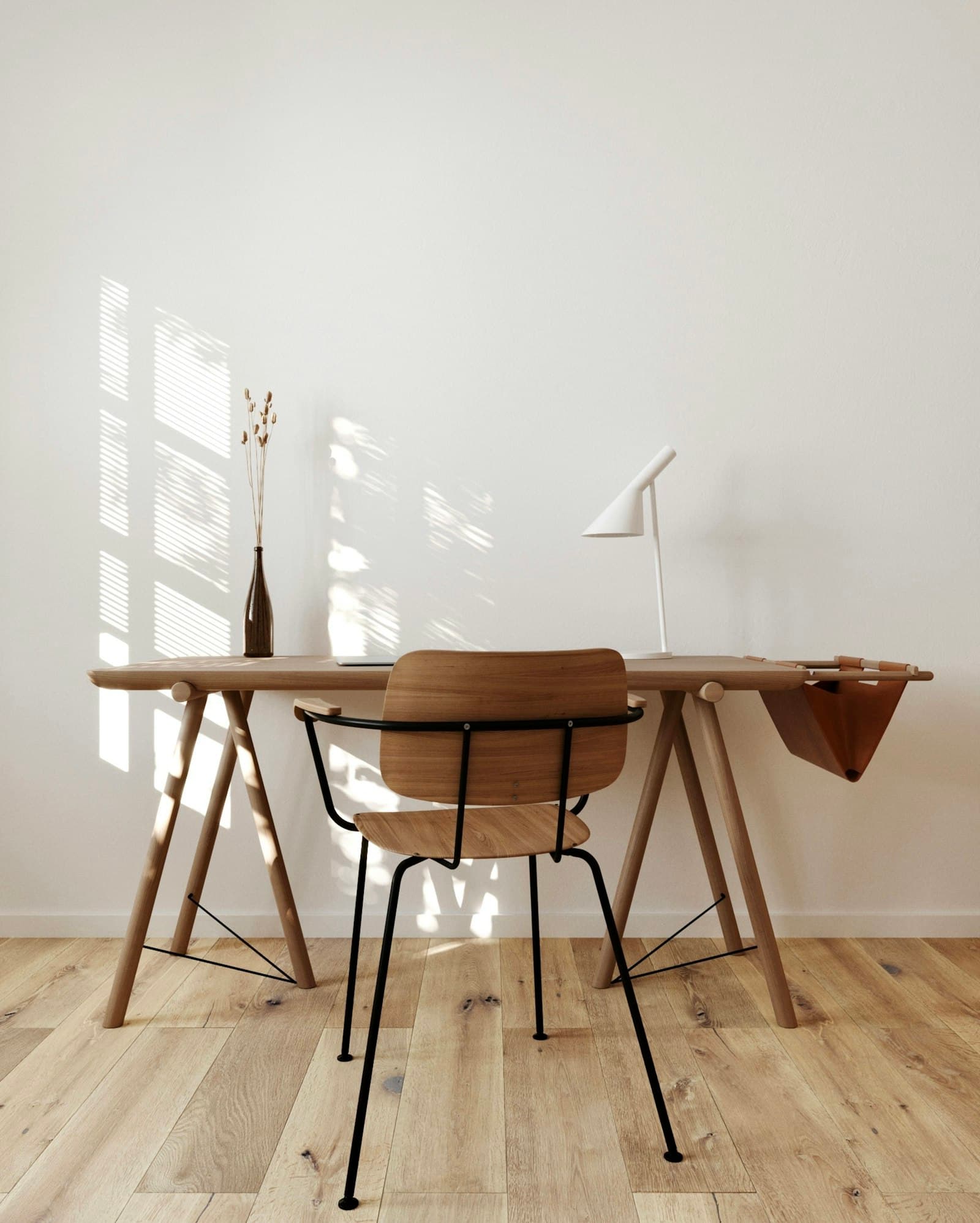 A three-legged oak stool beside the writing desk